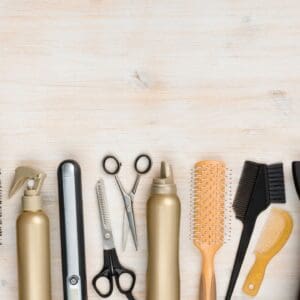 A wooden table topped with lots of hair tools.