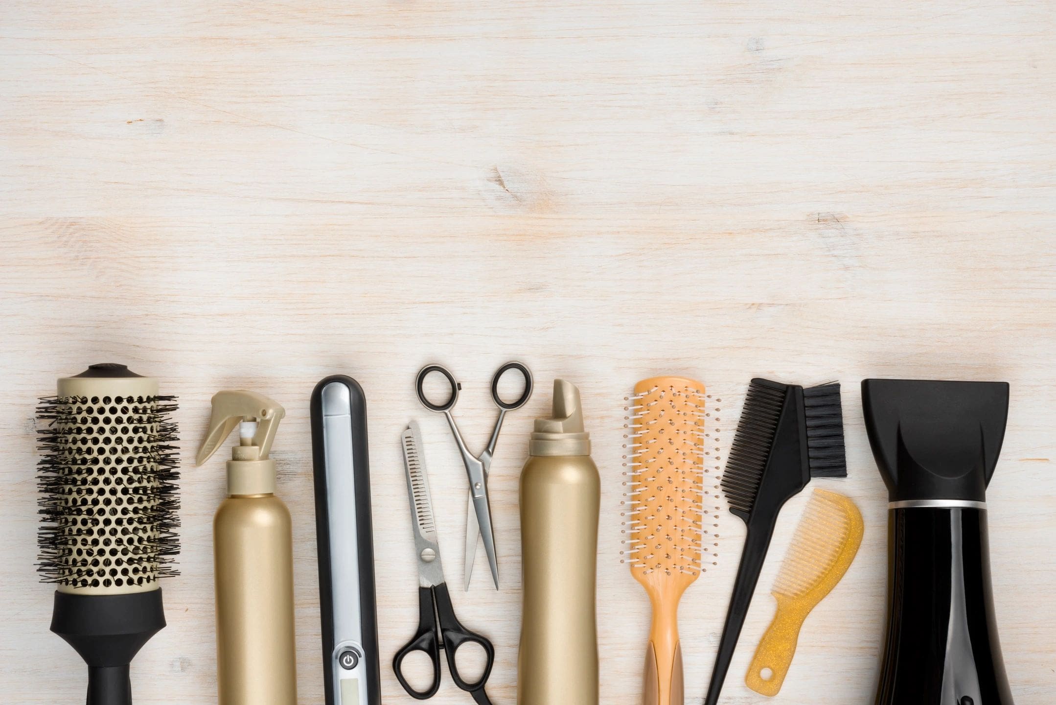 A wooden table topped with lots of hair tools.