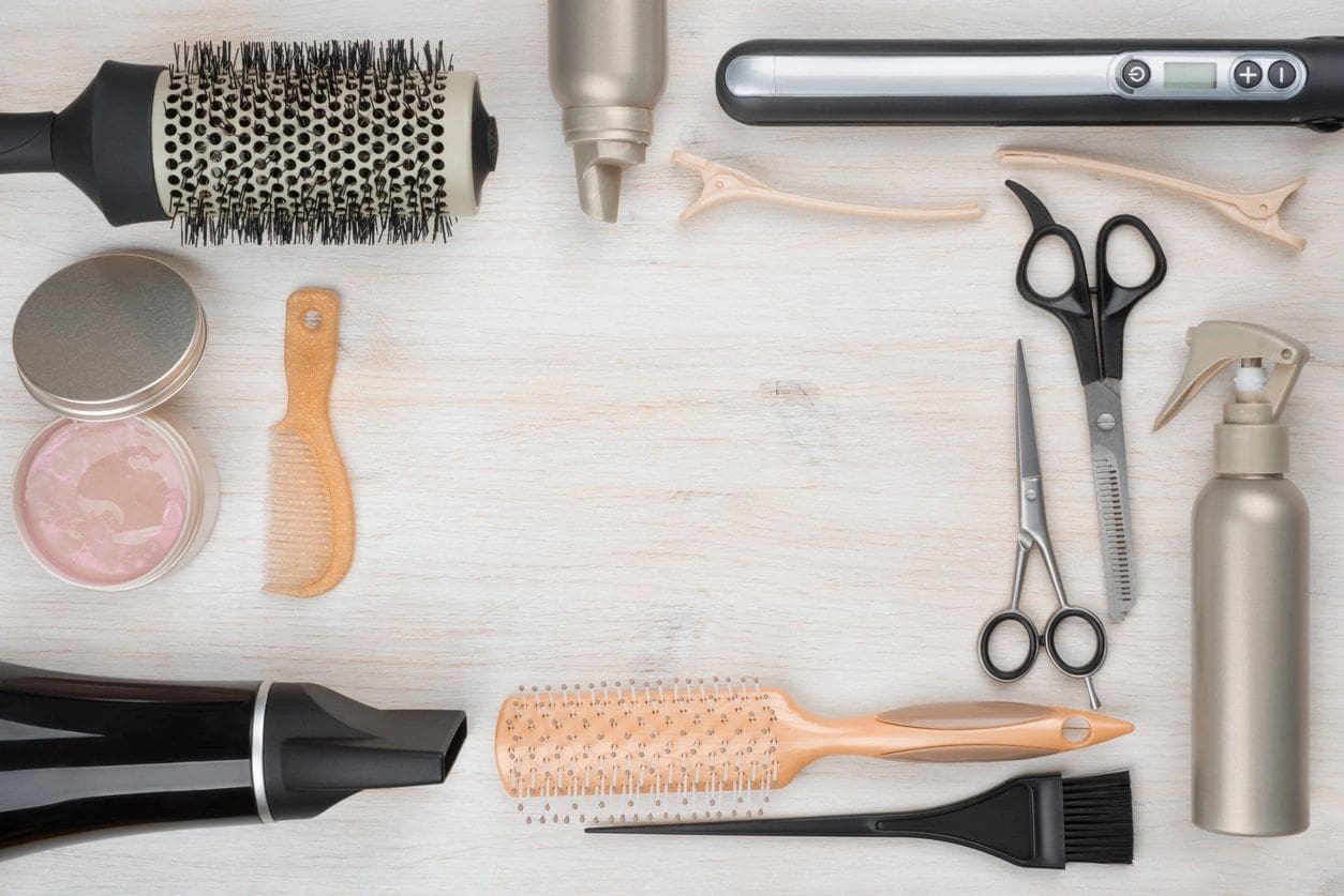 A wooden table topped with lots of hair tools.