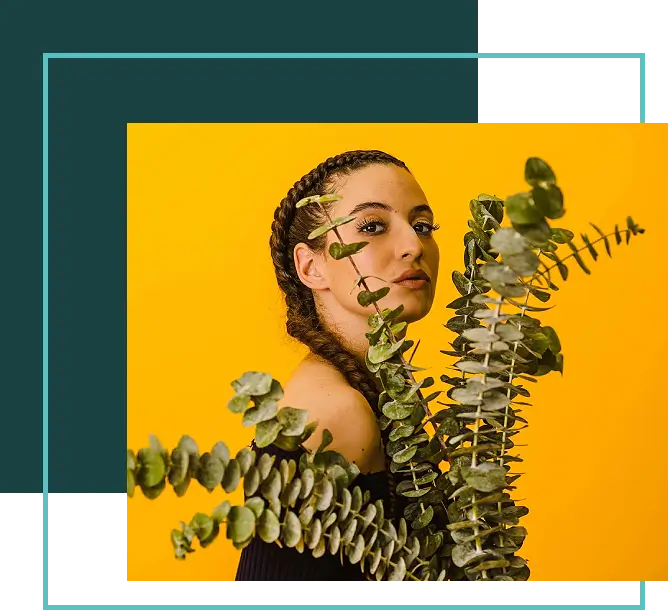 A woman with braids and a plant in her hair.